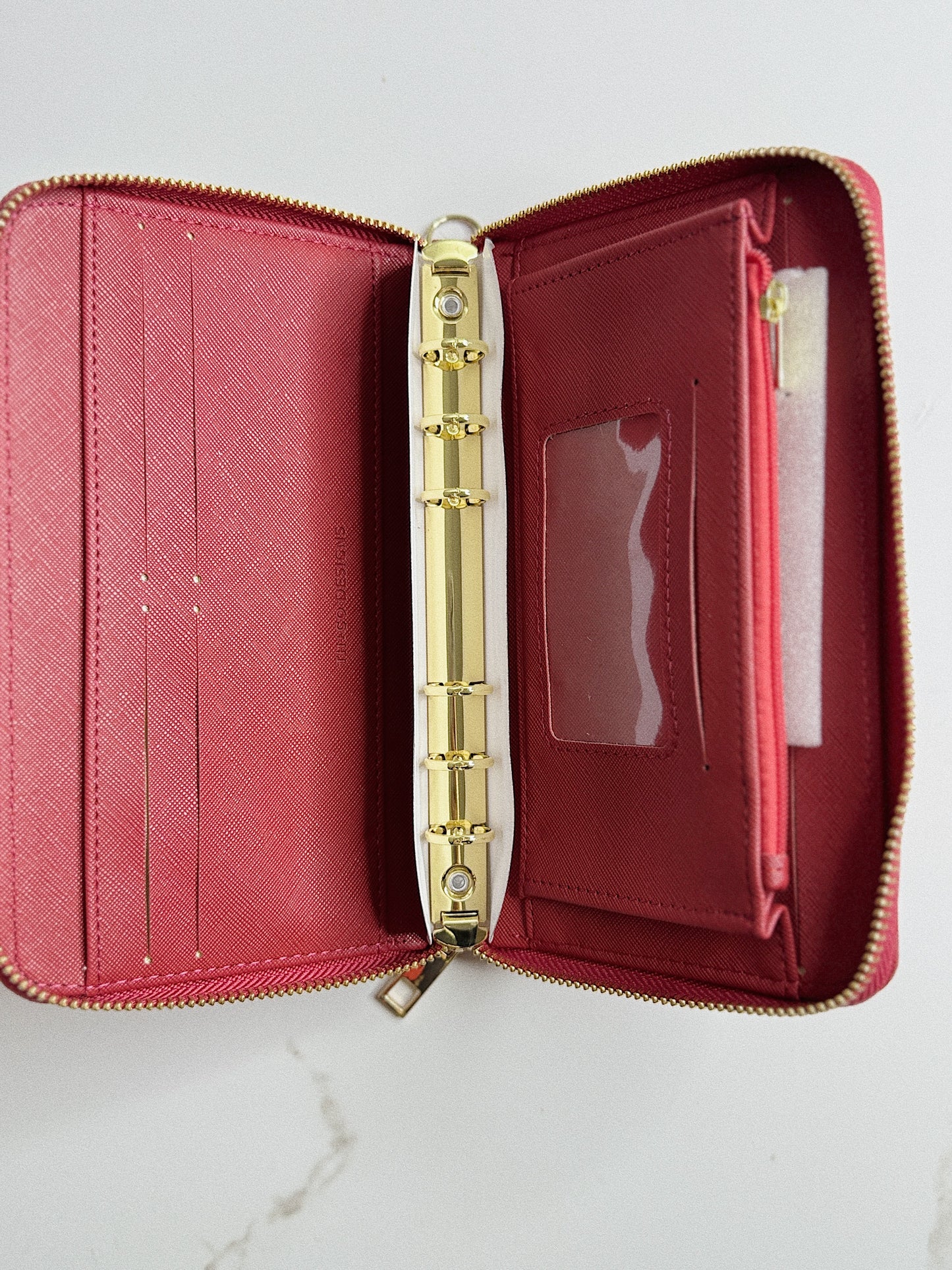 Open red wallet with gold zipper on a white background