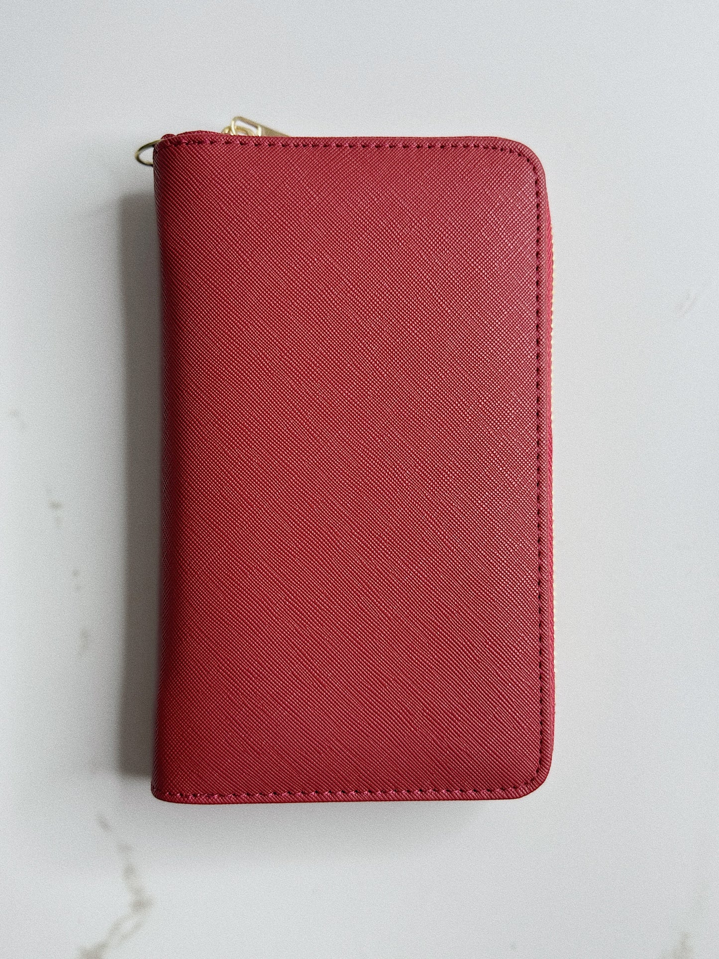 Red wallet with a gold zipper on a light gray background